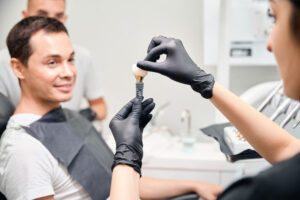 Aesthetic stomatology client watching at process of dental implant installation.