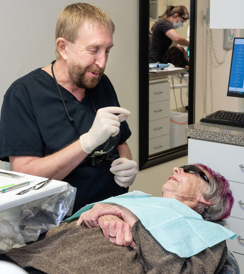 Elderly female dental patient receiving care and consultation from a dentist during a dental exam in Albuquerque NM.